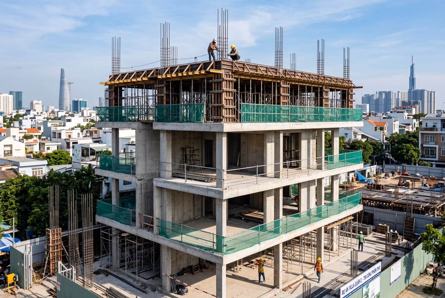 Khung bê tông cốt thép một ngôi nhà phố đang thi công, có lưới bao che và giàn giáo